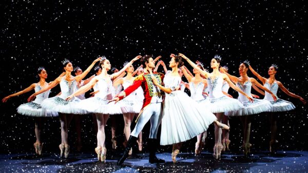 A couple dance in front of the corps de ballet
