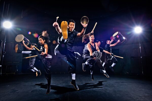 Dancers with drums jump in the air
