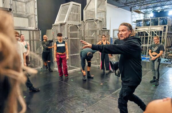 A man directs dancers