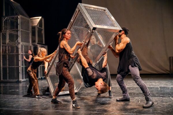 Dancers lower a tower