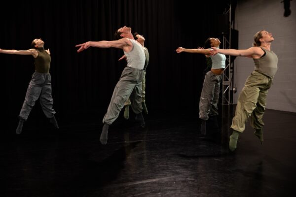 Dancers jump and lift their chests