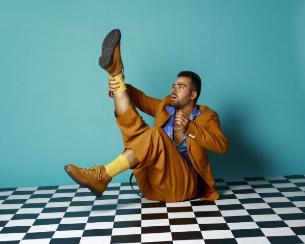 A man sits on a checkered floor