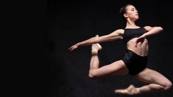 A dancer in black jumps in the air