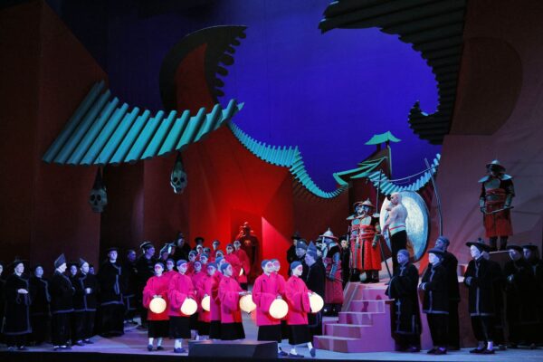 A group in pink jacket enter a stage from LA Opera's Turandot, featuring a set designed David Hockney