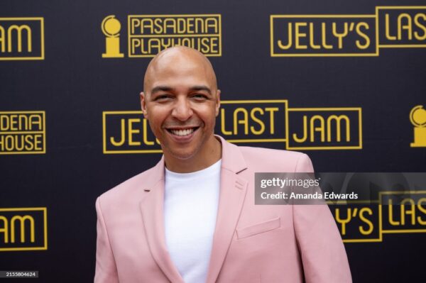 A man in a pink suit smiles at camera