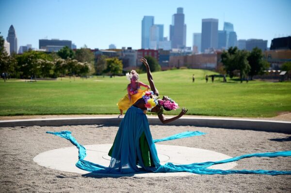 Two dancers with skyline behind them