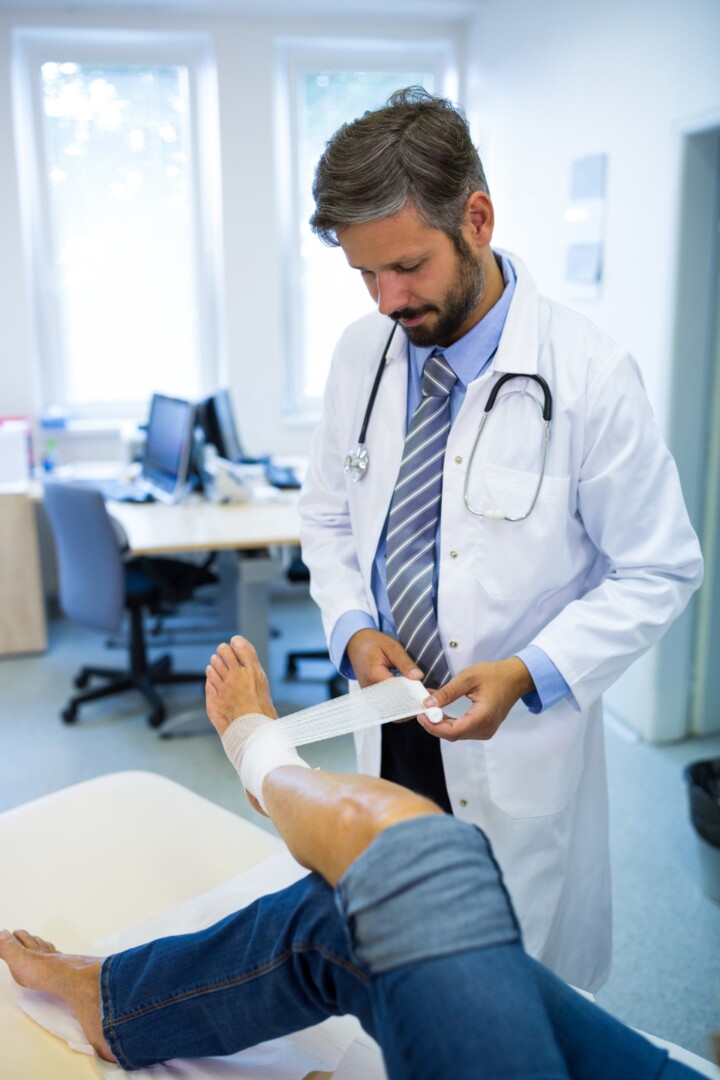 doctor wrapping a patient's ankls