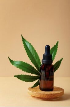 Bottle of THC syrup with marijuana leaf in the background.
