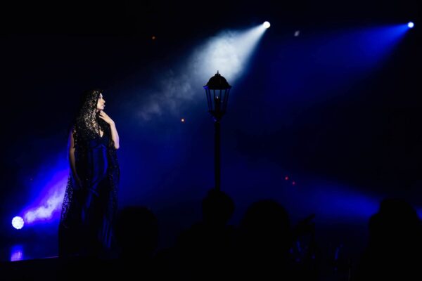 A woman in lace against a spotlight