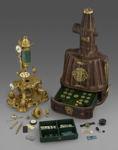 Compound Microscope and Case, With All Accessories, France, early 1750s, gilt bronze, iron, enamel, sharkskin and glass;wood, gilded leather, gilt bronze fittings, green silk velvet, gold braid; slides of various natural specimens and brass implements; Getty Museum.