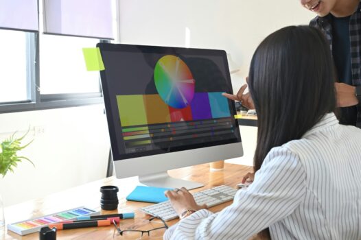 Two people looking at a color wheel on a computer.