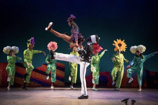 Dancers in green surround center couple
