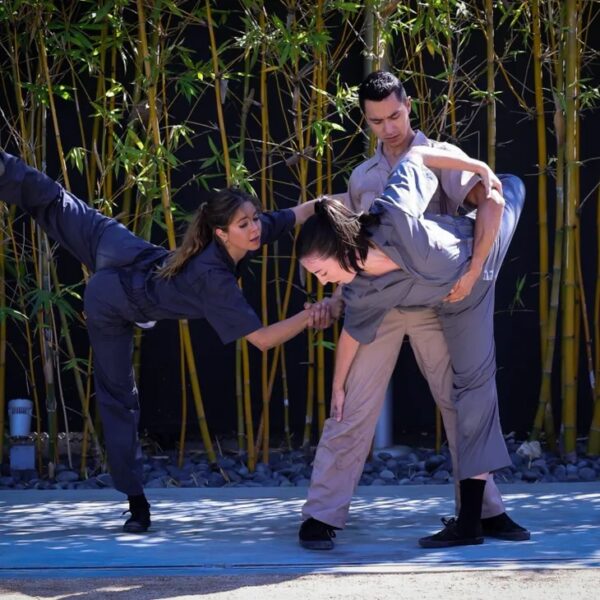 Three dancers in front of bamboo