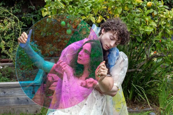two dancers look through a colored circle