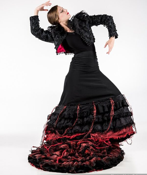 A flamenco dancer poses in a black dress
