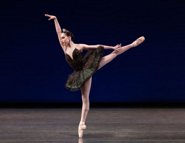 A ballerina in black tutu in arabesque