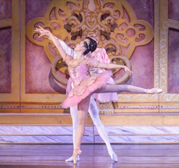 A ballerina is held by her partner