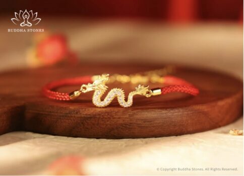 Red string bracelet displayed on wood.