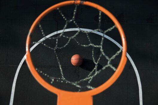 Birds-eye view of basketball through net.