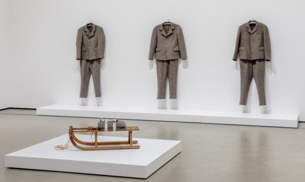 Joseph Beuys, Felt Suit, 1970, felt cloth (three versions on wall); Sled, 1969, wood, blanket, flashlight (foreground); installation photograph by Joshua White/JWPictures.com, courtesy of the Broad.
