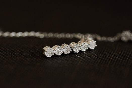 A closeup of a diamond necklace on a dark surface