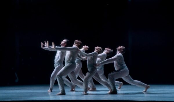 A line of dancers in white