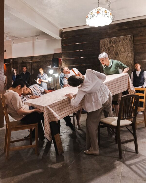 A group of dancers around a tilting table