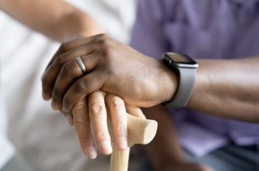 Elderly man and woman holding one cane.