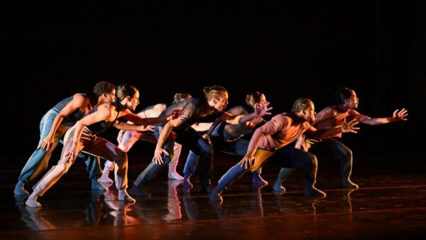 A group of dancers look to stage left