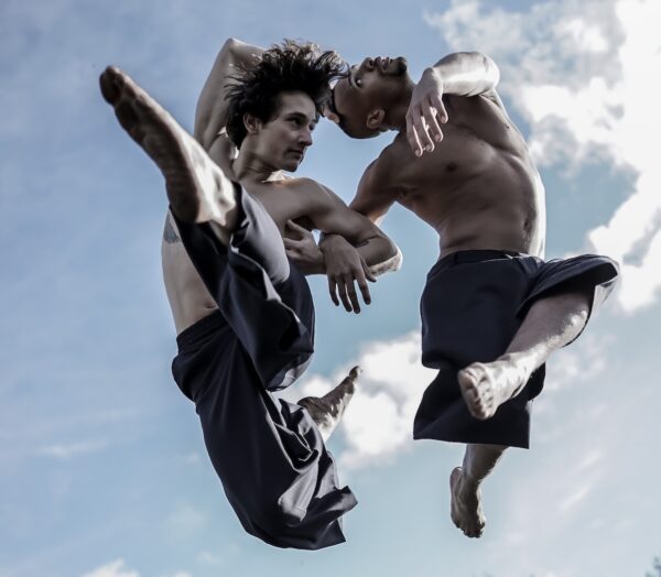 Two men leap in the air