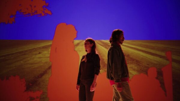 Two figures move across screen