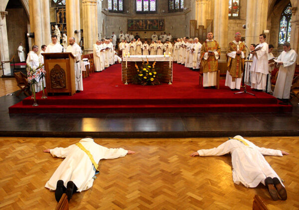two priests laying in prostration inside a church