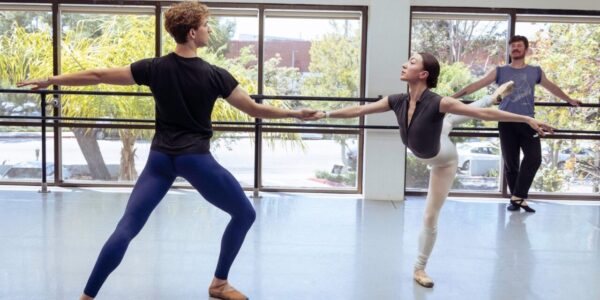 Dancers rehearse before a choreographer
