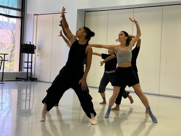 A group of dancers lift their arms