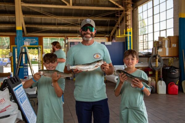 A family holding up fish
