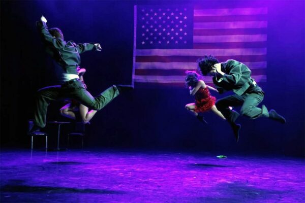 Dancers jump in purple lighting