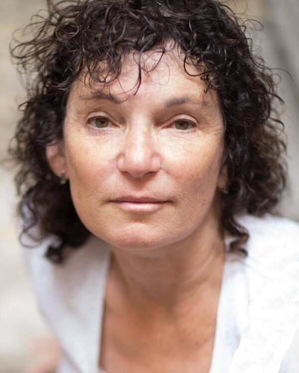 woman with curly hair looks at camera