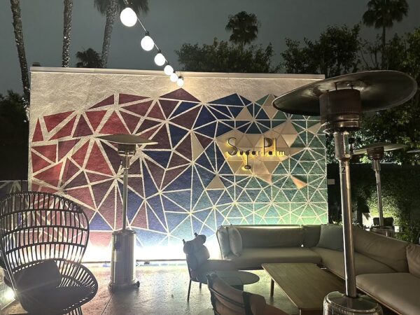 A poolside mural by Evelyn Leigh done in geometric shapes with blue and violet shades.