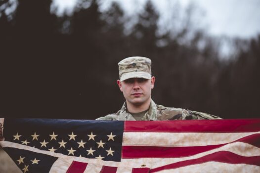 A shallow focus shot of an American soldier holding the American flag