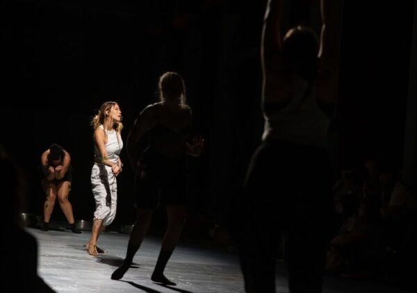 Dancer in white amid shadows