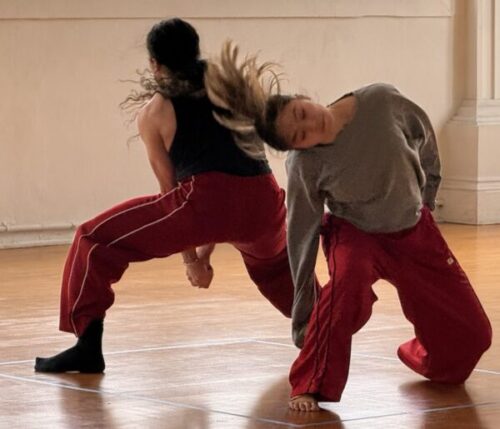 Two dancers in red pants