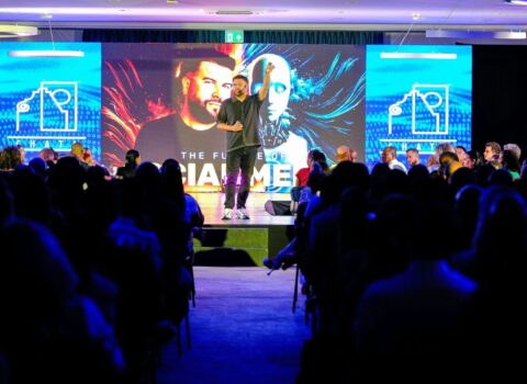 Speaker presenting on stage to an audience