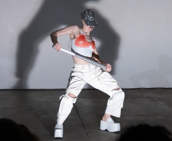 A dancer in white with a red bra