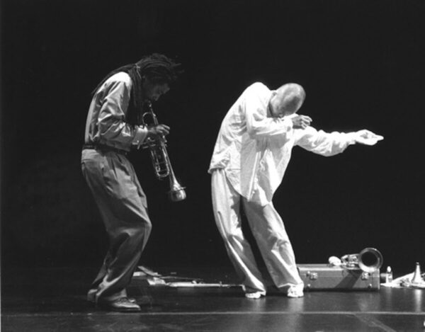 A dancer in white with a musician