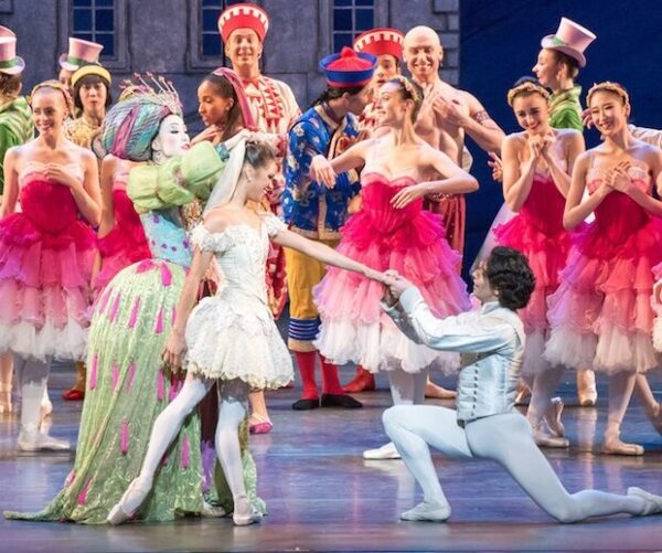 A dancer in green with more dancers