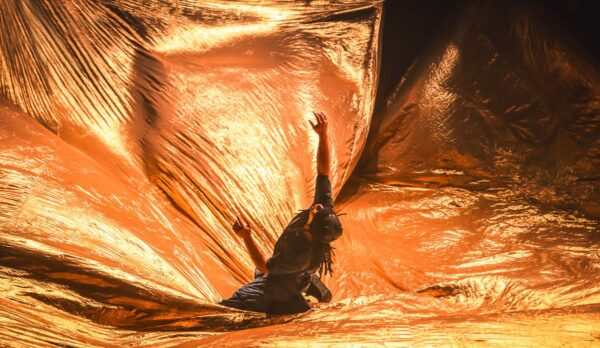 A man inside gold fabric