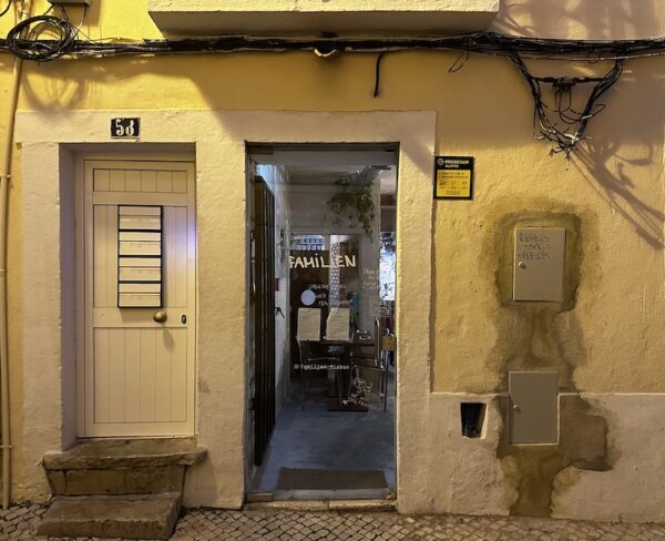 The front door of the Familjen restaurant set against a pale yellow exterior.
