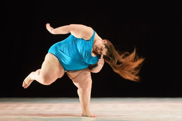A woman in a blue swimsuit and long hair