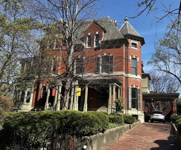 The JB Speed Mansion - very large with peaked roofs, made of red stone. There is a driveway to the right. 