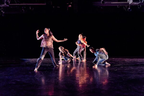 A group of dancers look offstage